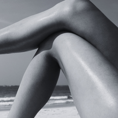 Woman's legs on the beach in summer sun - post-summer skin care and UV damage recovery