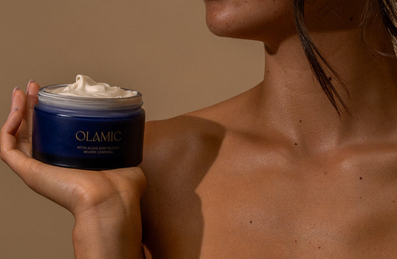 Person holding a jar of OLAMIC Retin-Algae Body Butter