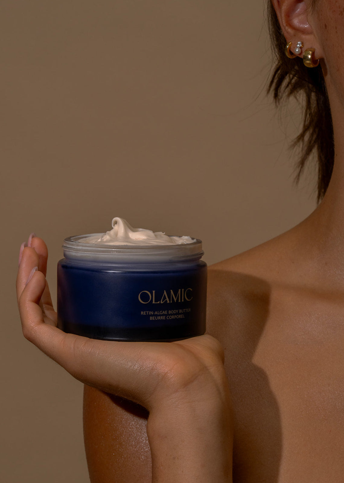 Woman holding OLAMIC Retin-Algae Body Butter